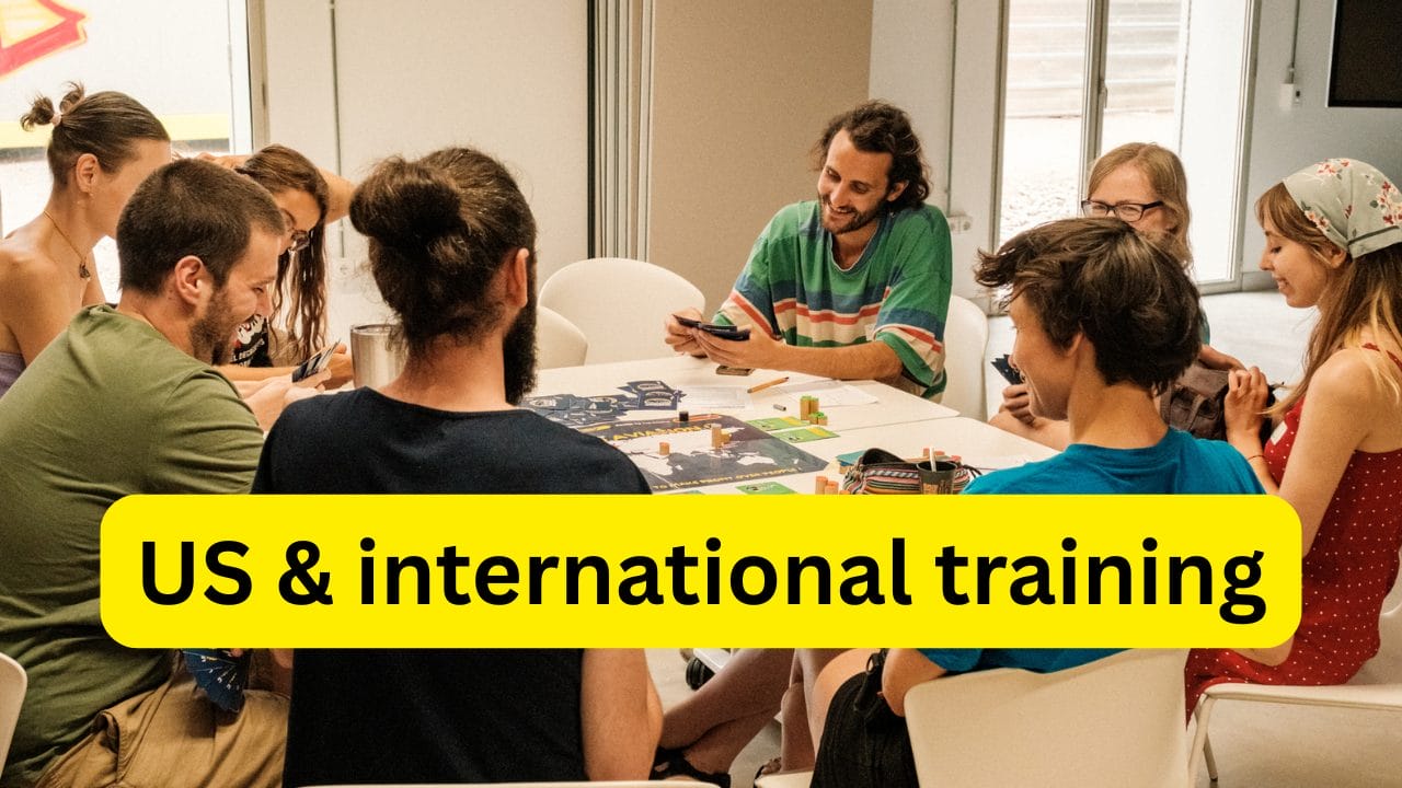 Photo of people at a Stay Grounded conference sitting around a table chatting and laughing.